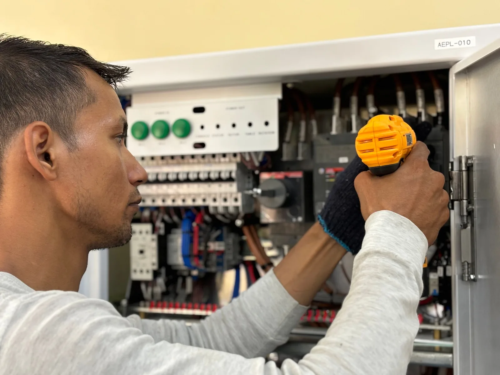 An electrician working on a commercial control panel, for subpanel installation in Winnipeg