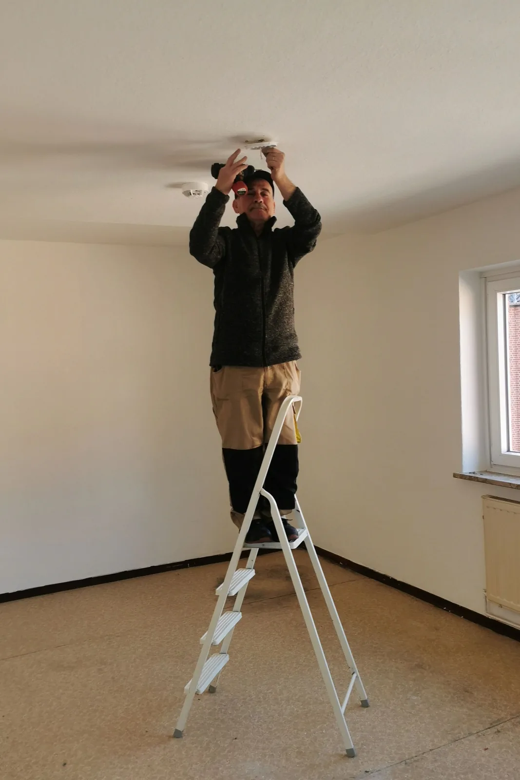 Fitting a ceiling detector from a step ladder, for electrical permit in Winnipeg